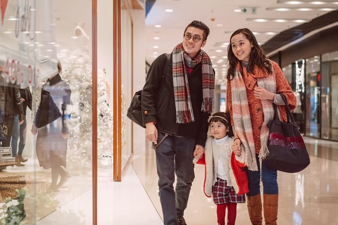 China Chinese family consumer Happy family with Mom, dad and lovely little daughter strolling in shopping mall joyfully during Christmas.